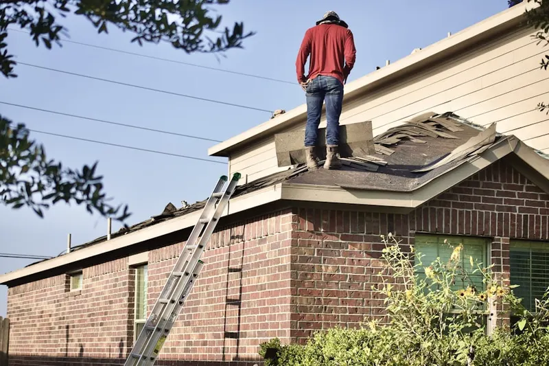 Professional roofer working on a residential roof in Demopolis